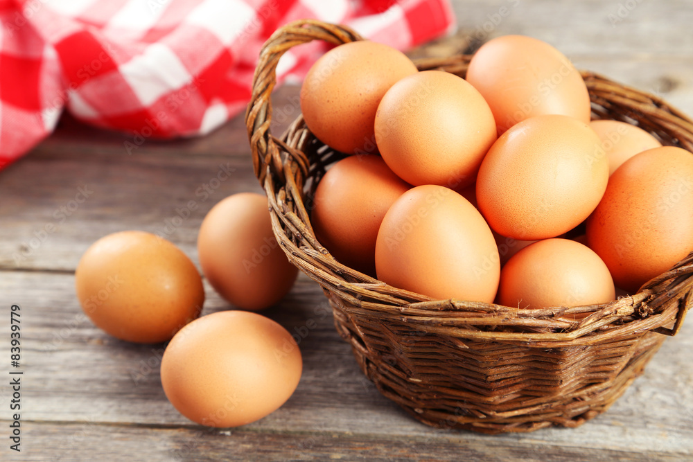 Chicken eggs in basket on grey wooden background Chicken eggs in basket on grey wooden background