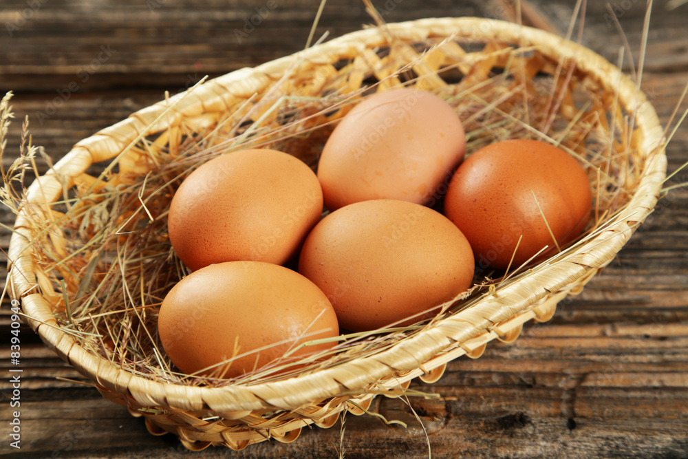 Eggs in basket on brown wooden background Eggs in basket on brown wooden background