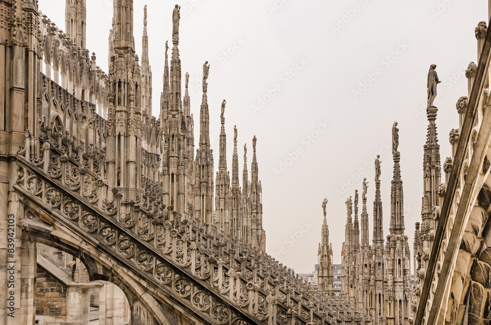 Detail view of stone sculptures on roofs of Duomo Milano Detail view of stone sculptures on roofs of Duomo Milano
