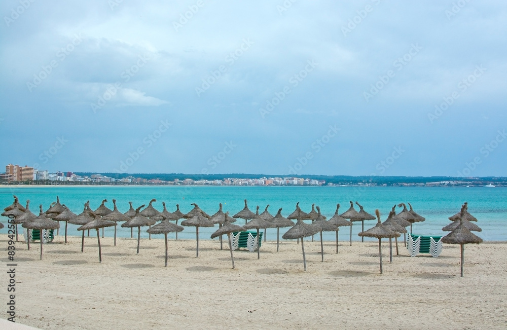 Can Pastilla beach with sun parasols in spring. Mallorca.
