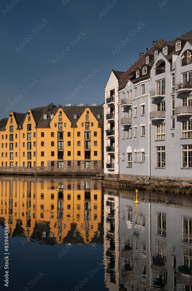 Obraz premium Jugend buildings in Alesund, Norway, reflected in beautiful calm sea. Vertical.