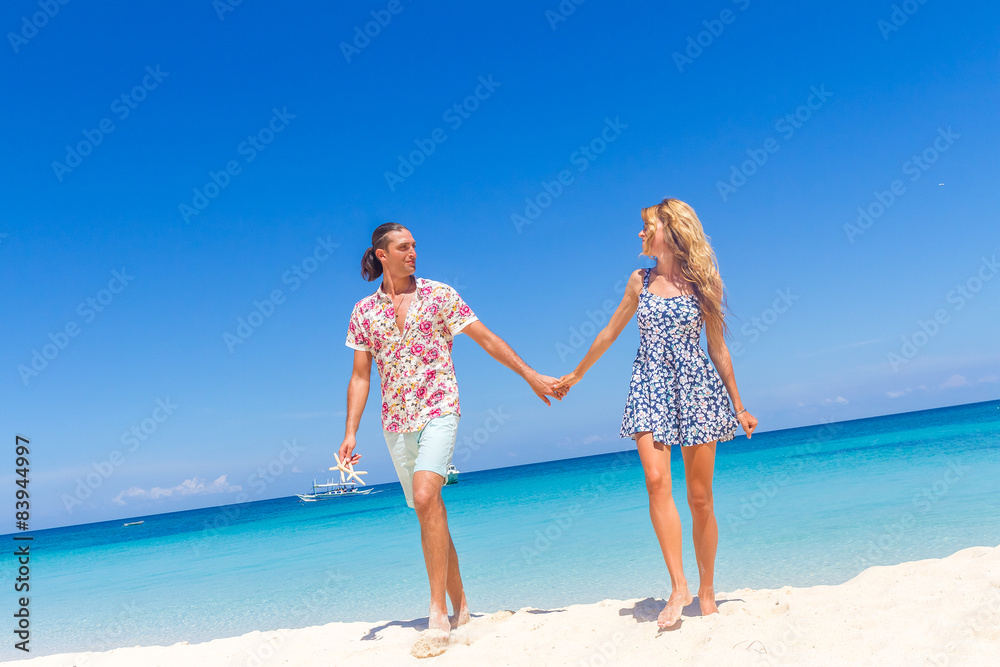Beach couple walking on romantic travel honeymoon vacation summe