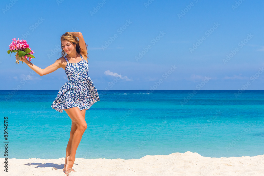 young happy girl with flower bouquet on tropical sea and beach b