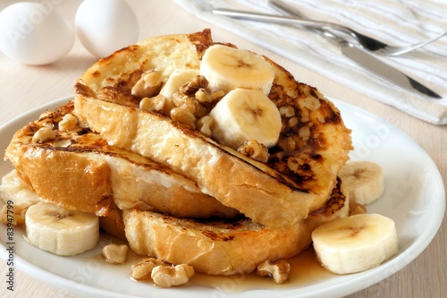 Fotografija French toast with bananas, walnuts and dripping maple syrup