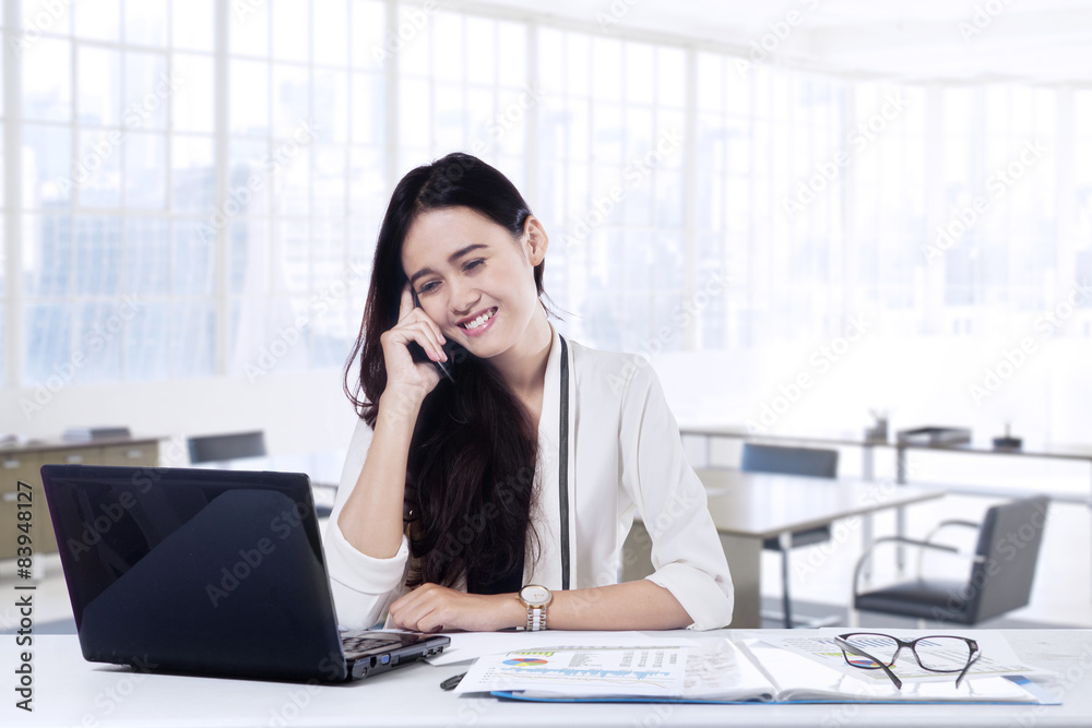 Employee talking on the mobile phone in office Employee talking on the mobile phone in office