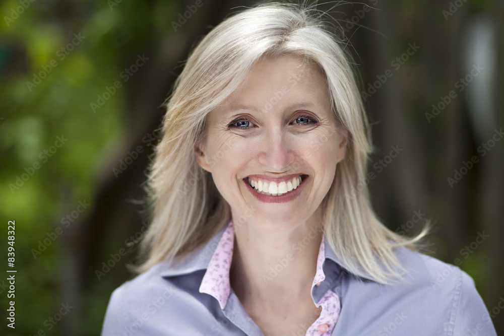 Fototapeta premium Mature Woman smiling at the camera. She is working at home