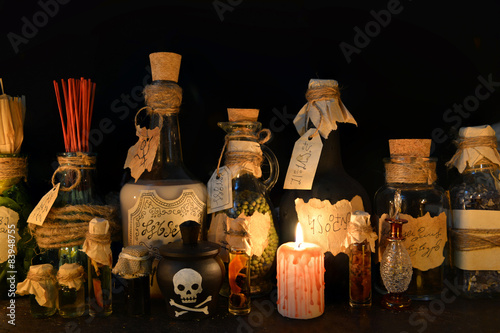 Halloween still life with witch bottles and bloody candle