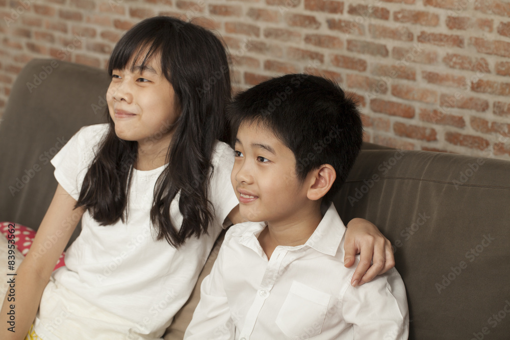 Thai relatives brother sister sit at sofa together playing game Thai relatives brother sister sit at sofa together playing game