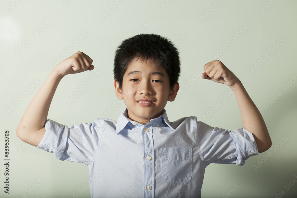 Asian healthy boy showing strong arms with dumbbell Asian healthy boy showing strong arms with dumbbell