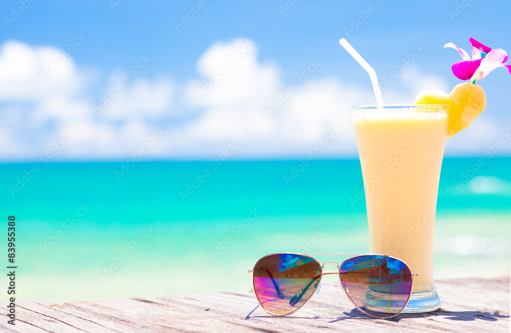 picture of fresh banana and pineapple juice and sunglasses on