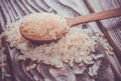 white rice in spoon on wooden background