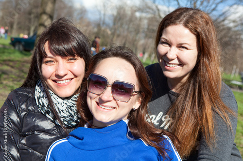 Three smiling Caucasian attractive women looking at camera