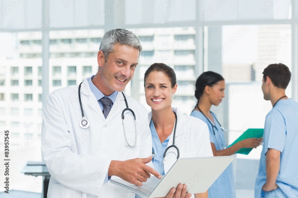 Male and female doctors working on reports Male and female doctors working on reports