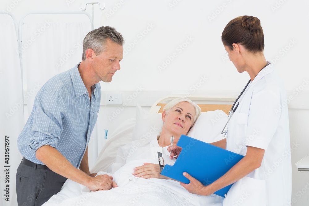 Obraz premium Doctor explaining report to female patient and husband