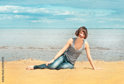 Happy woman sitting on the beach