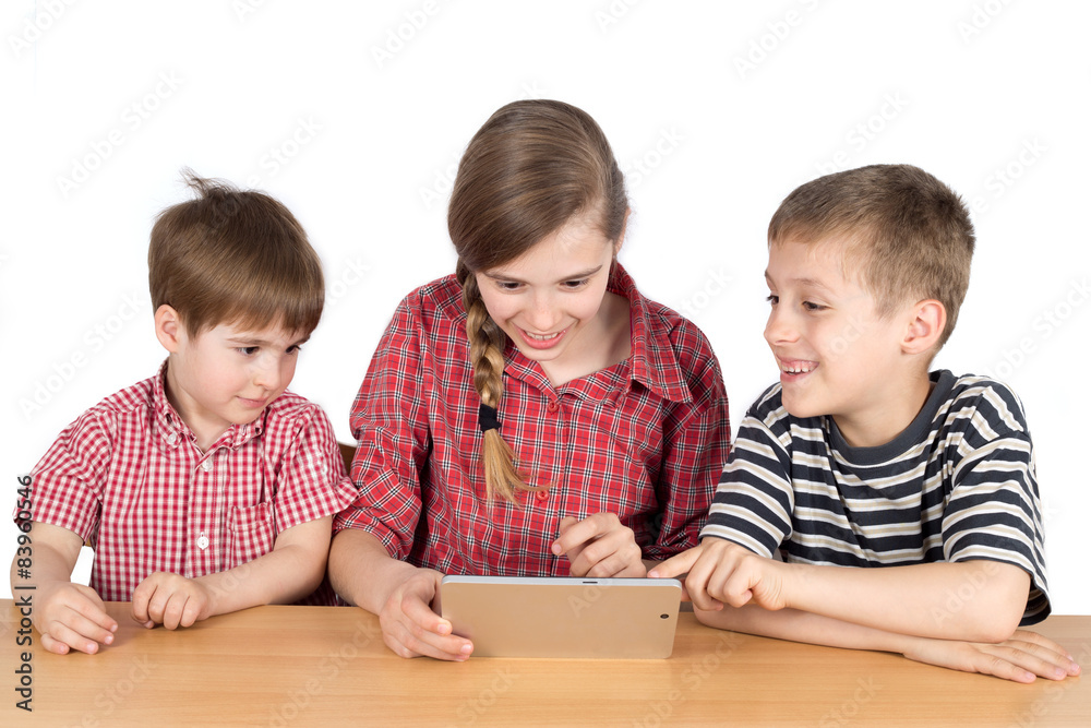 Happy Siblings Sitting at the Desk and Using Tablet Isolated Happy Siblings Sitting at the Desk and Using Tablet Isolated