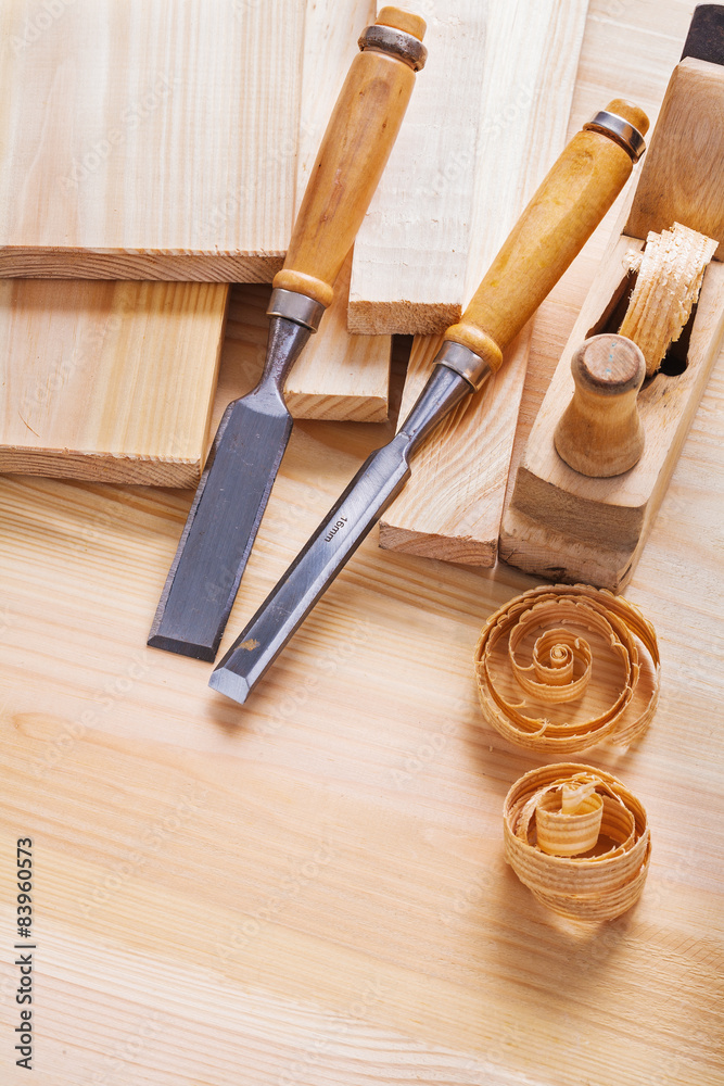 joinery chisels and woodworkers plane with shawings on wooden bo