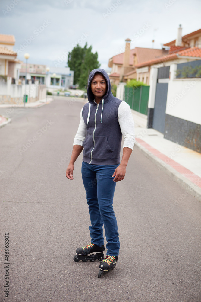 Hooded afroamerican guy with skates Hooded afroamerican guy with skates