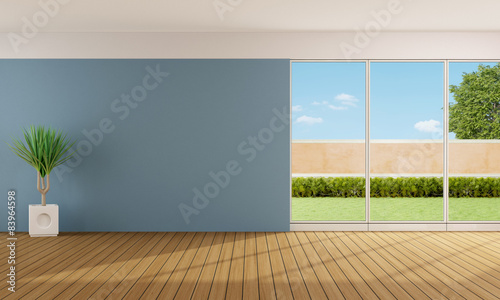 Empty living room with blue wall and large windows 