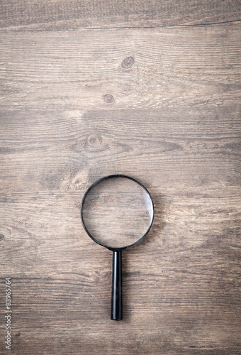 Magnifying glass on wooden table, Search and discover symbol