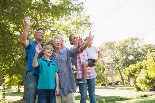 Happy family waving hands in the park