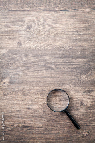 Magnifying glass on wooden table, Search and discover symbol