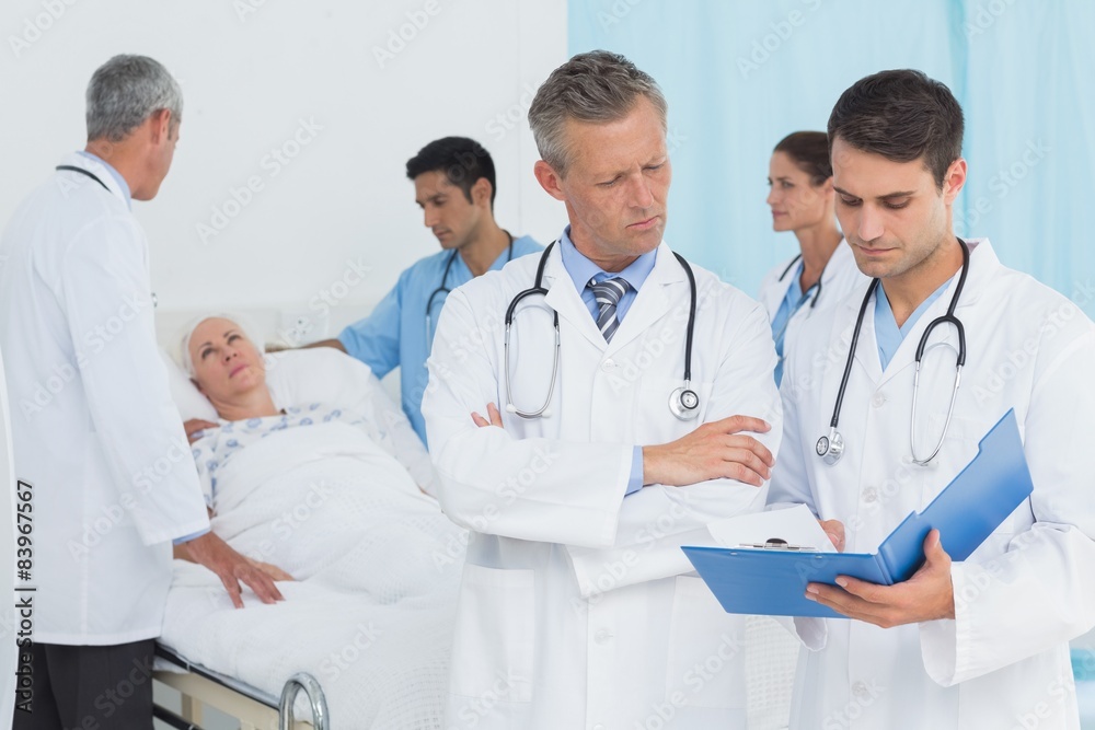 Report reading with colleagues and patient behind Report reading with colleagues and patient behind