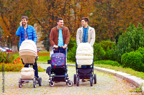 three happy fathers on city walk in park