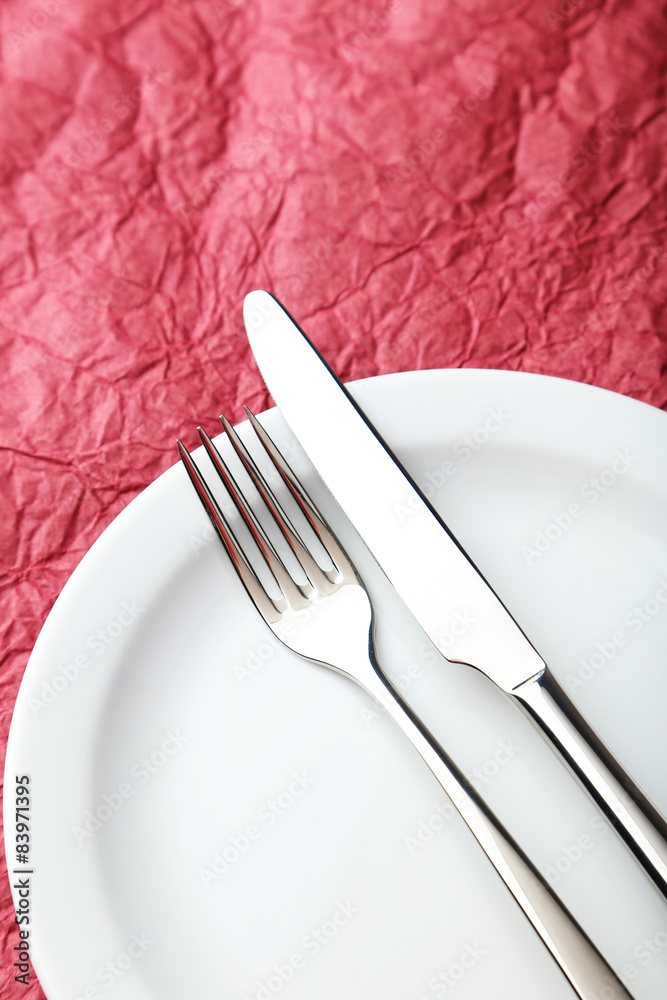 Fork, knife and plate on red background Fork, knife and plate on red background