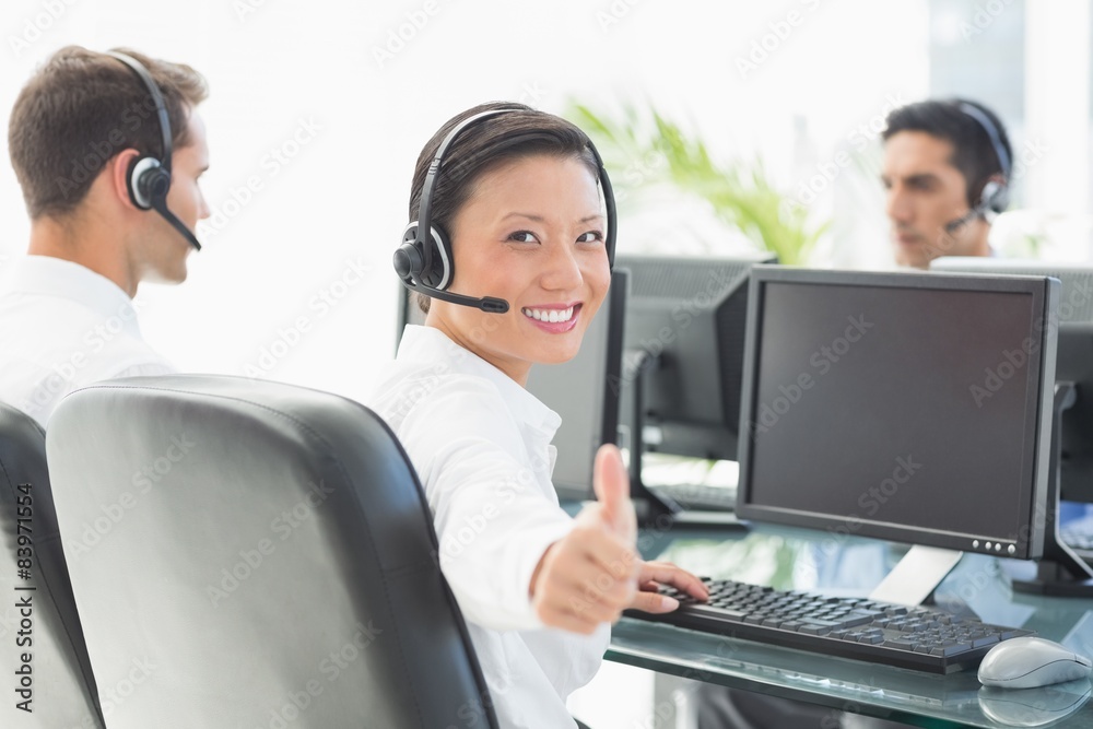Businesswoman with thumbs up at call centre Businesswoman with thumbs up at call centre
