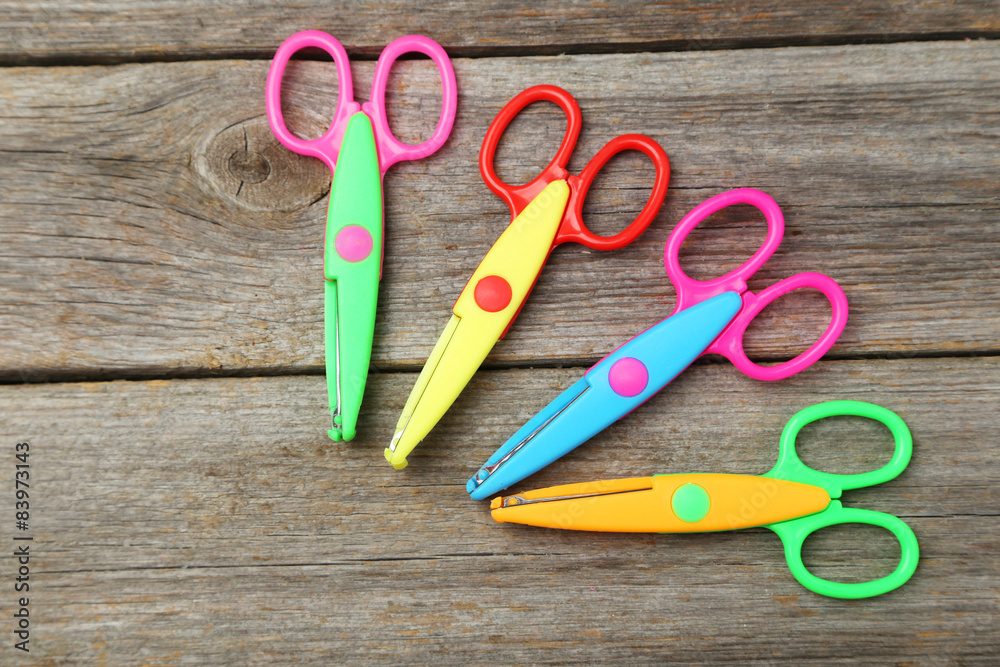 Figured scissors on grey wooden background Figured scissors on grey wooden background