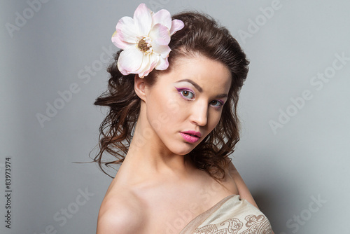 Beauty portrait of a girl with a flower in her hair. 