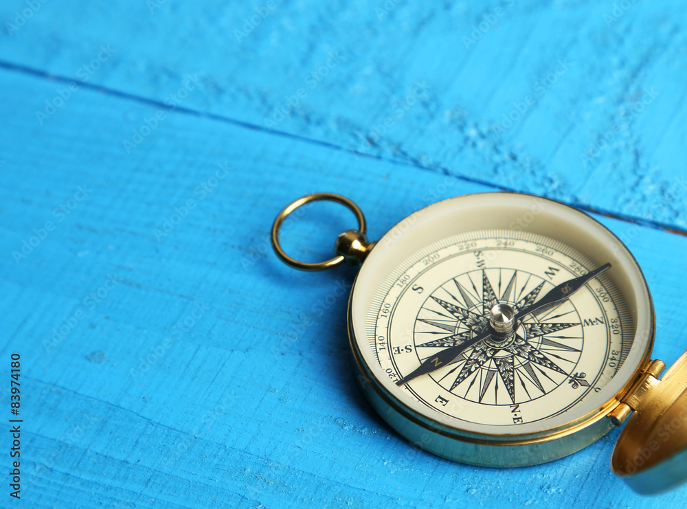 Compass on blue wooden background