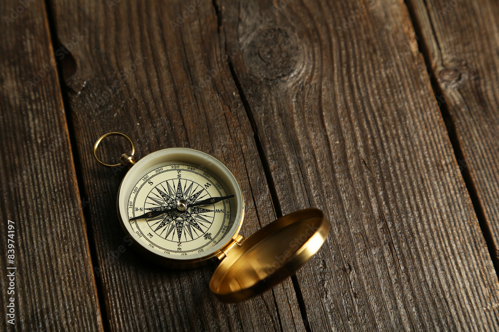 Compass on brown wooden background Compass on brown wooden background