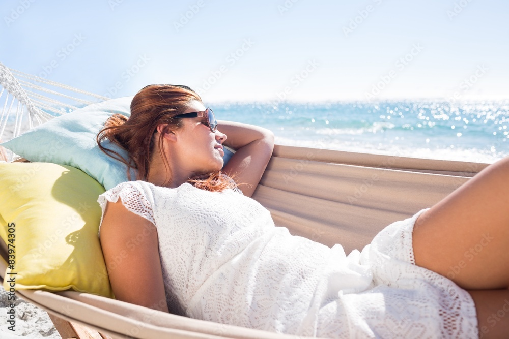 Brunette relaxing in the hammock with sunglasses