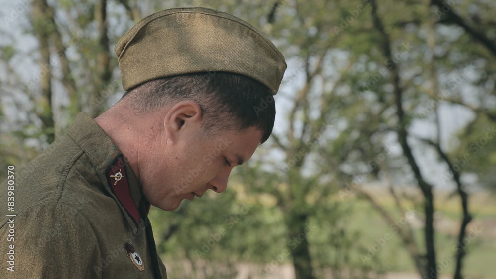 A soldier smokes a cigarette in the forest