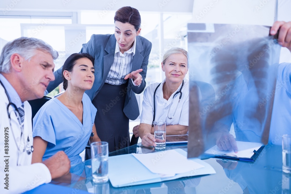 Team of doctors and businesswoman examining xray Team of doctors and businesswoman examining xray