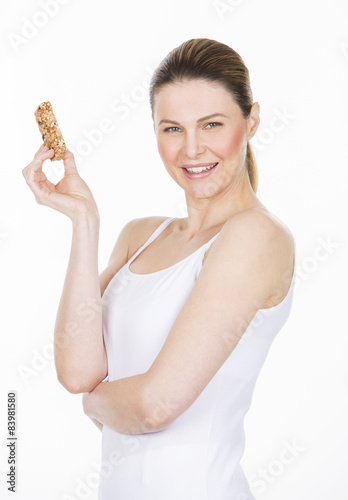 woman with white dress holding a healthy fruit bar