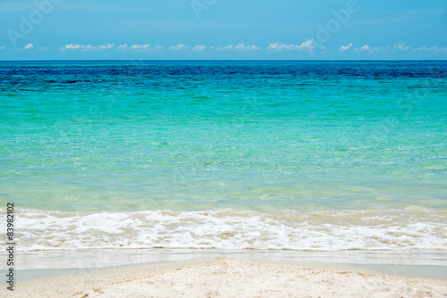 Close up on the edge of a beach with turquoise water