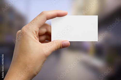 Hands holding a white business visit card, gift, ticket, pass