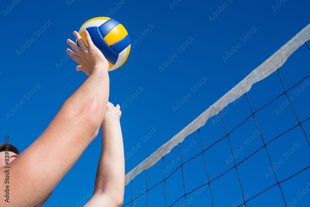 Man throwing volleyball above the net