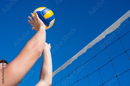 Man throwing volleyball above the net