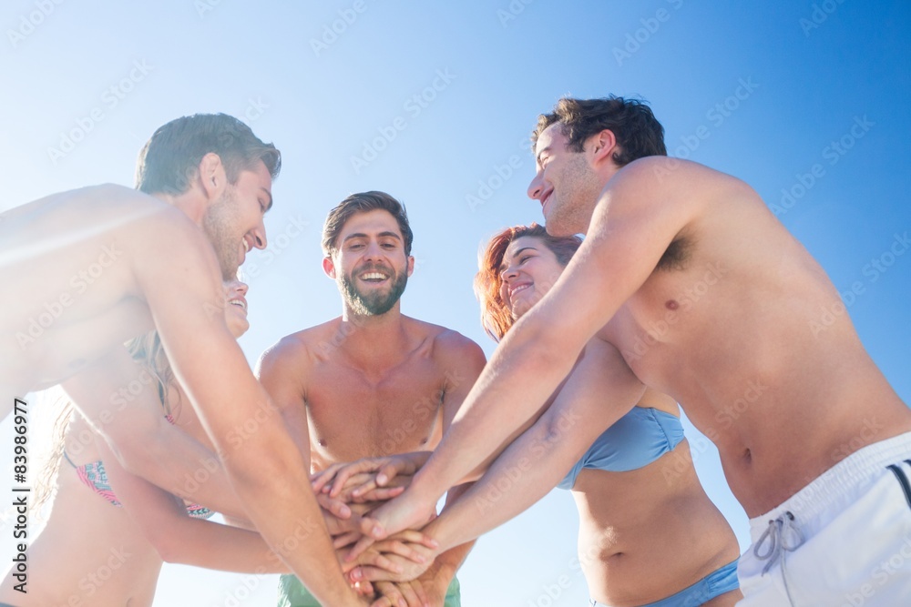 Group of friends standing in circle hands together Group of friends standing in circle hands together