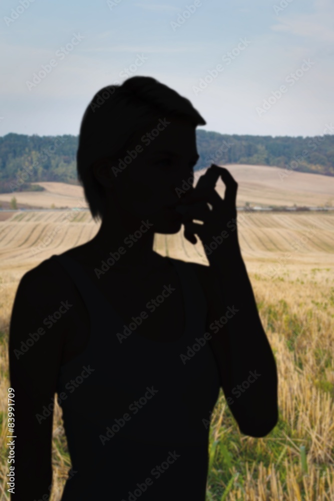 Composite image of blonde woman taking her inhaler Composite image of blonde woman taking her inhaler