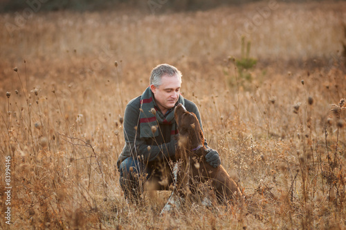 man in a field with his springer spaniel dog