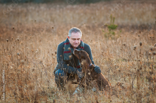 man in a field with his springer spaniel dog