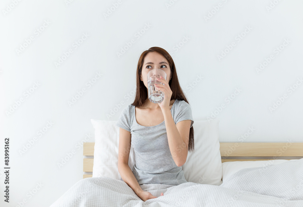 Asian woman drinking a glass of water at living room Asian woman drinking a glass of water at living room