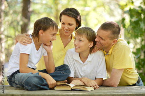 Family of four reading outdoors