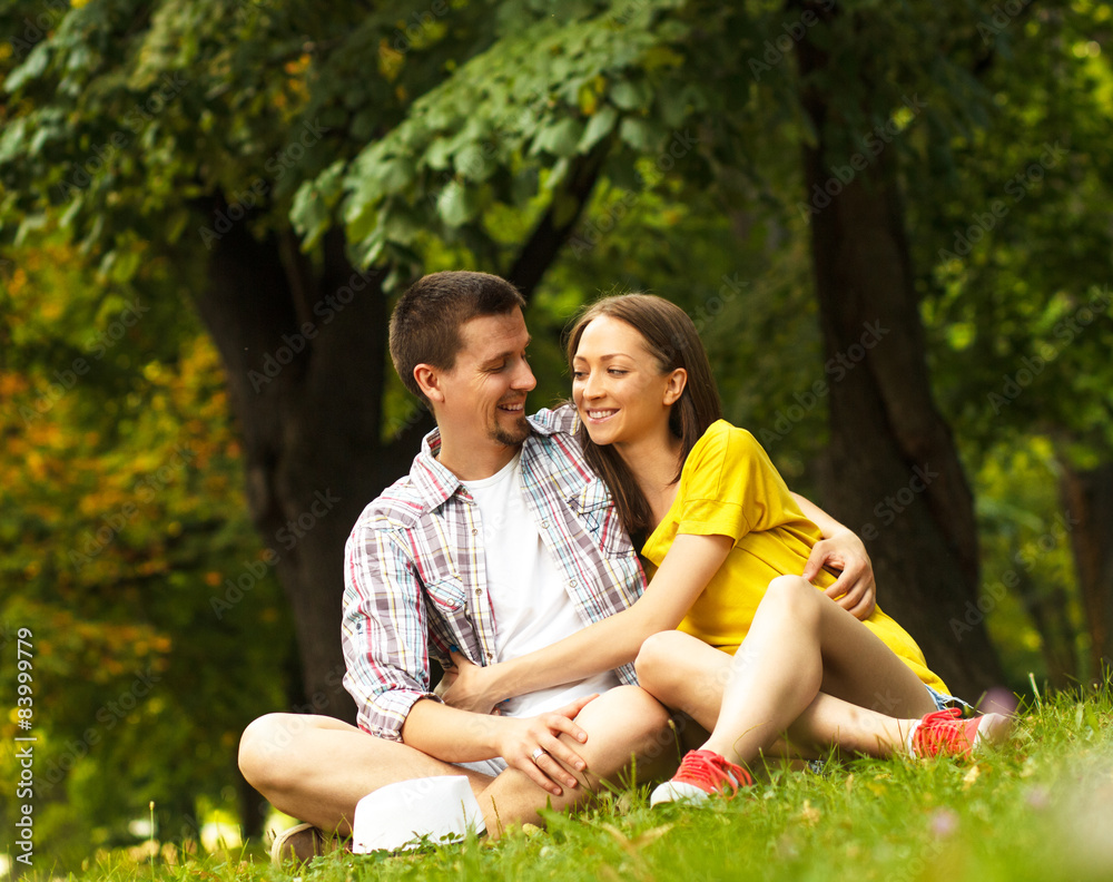 Fototapeta premium Affectionate young couple sitting in park