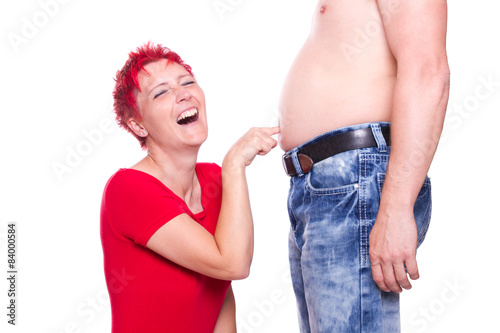 Frau sticht in dicken Bauch und lacht